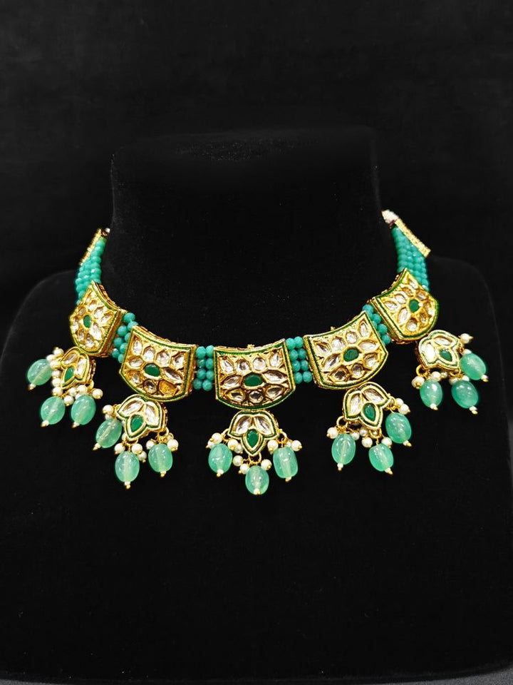 Close-up of an ornate traditional (Gold Polish) Mint Green Choker jewellery set and earrings with Pearl, Crystal stones, Kundan, Colored Stones and Tumble Beads. Mehendi ceremony look completed with a handcrafted Kundan jewelry set. Wedding celebration look enhanced with a statement Kundan necklace.
