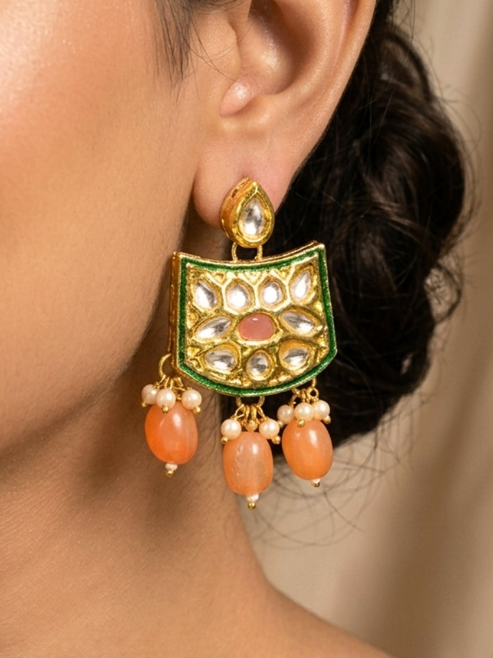 Close-up of a woman wearing an ornate traditional (Gold Polish) Peach Choker jewellery set and earrings with Pearl, Crystal stones, Kundan, Colored Stones and Tumble Beads. Mehendi ceremony look completed with a handcrafted Kundan jewelry set. Wedding celebration look enhanced with a statement Kundan necklace.