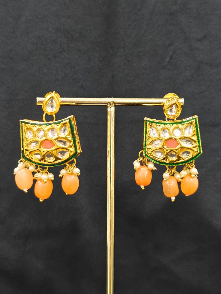 Close-up of an ornate traditional (Gold Polish) Peach Choker jewellery set and earrings with Pearl, Crystal stones, Kundan, Colored Stones and Tumble Beads. Mehendi ceremony look completed with a handcrafted Kundan jewelry set. Wedding celebration look enhanced with a statement Kundan necklace.