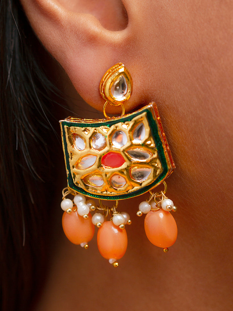Close-up of a woman wearing an ornate traditional (Gold Polish) Peach Choker jewellery set and earrings with Pearl, Crystal stones, Kundan, Colored Stones and Tumble Beads. Mehendi ceremony look completed with a handcrafted Kundan jewelry set. Wedding celebration look enhanced with a statement Kundan necklace.