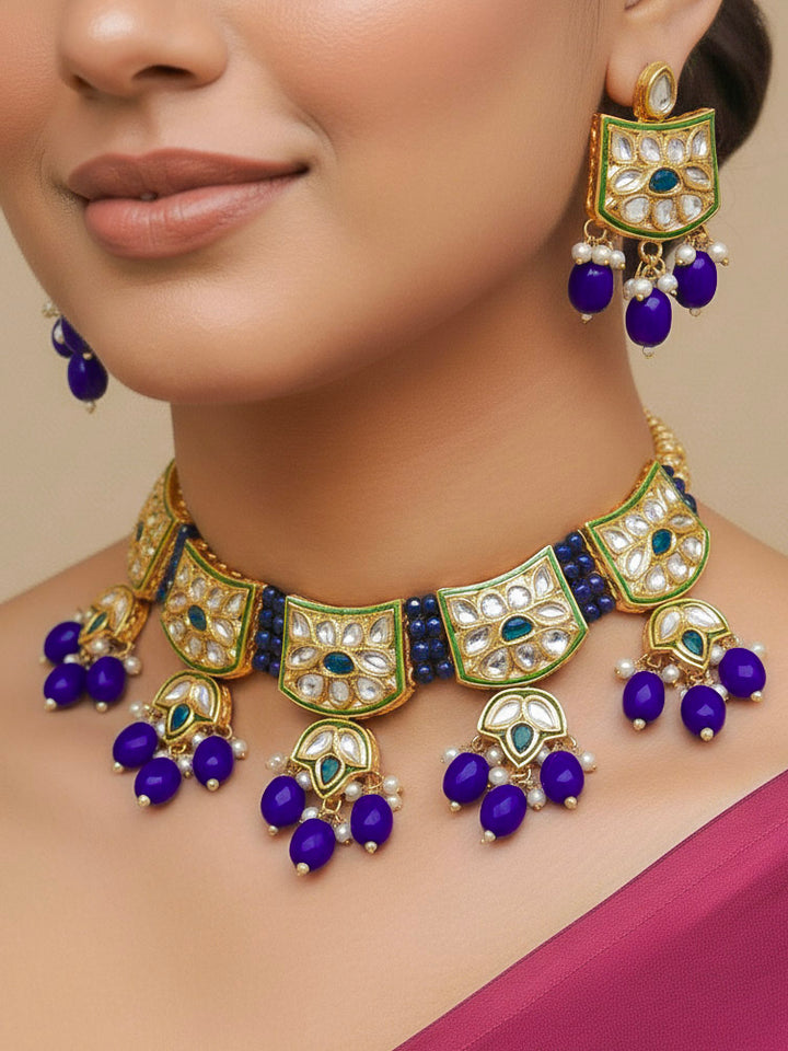 Close-up of a woman wearing an ornate traditional (Gold Polish) Purple Choker jewellery set and earrings with Pearl, Crystal stones, Kundan, Colored Stones and Tumble Beads. Mehendi ceremony look completed with a handcrafted Kundan jewelry set. Wedding celebration look enhanced with a statement Kundan necklace.
