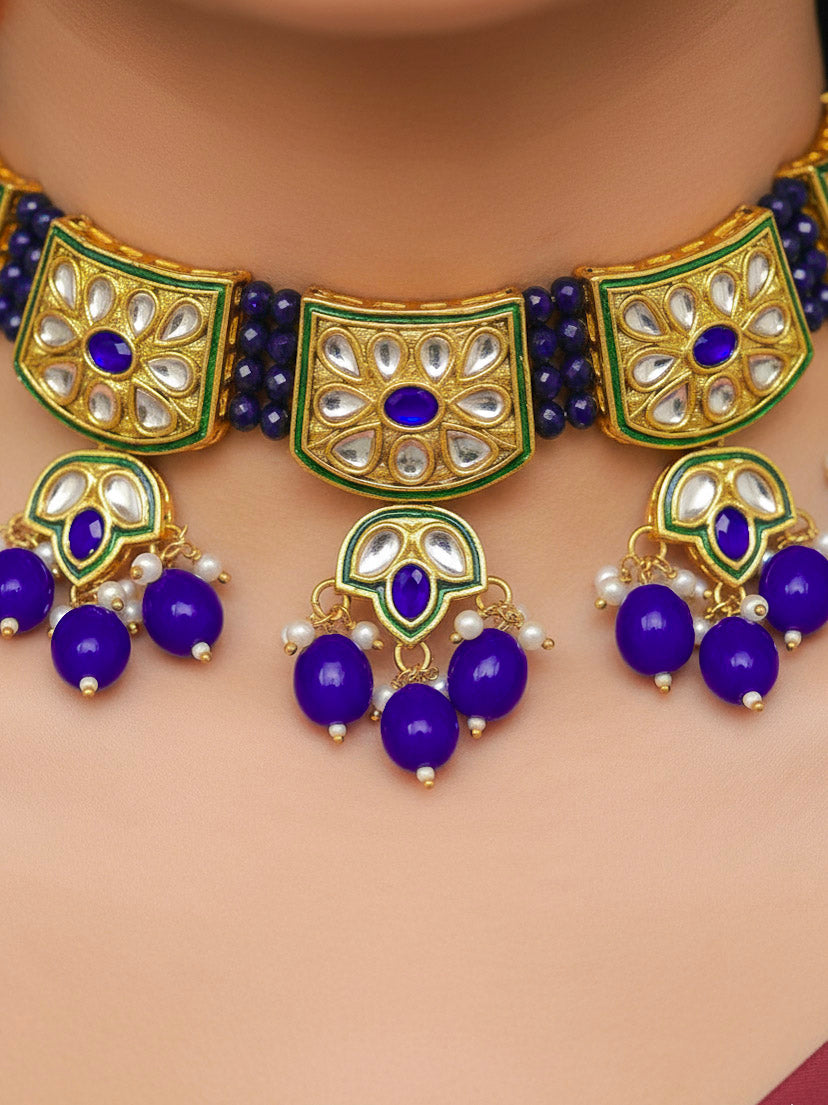 Close-up of a woman wearing an ornate traditional (Gold Polish) Purple Choker jewellery set and earrings with Pearl, Crystal stones, Kundan, Colored Stones and Tumble Beads. Mehendi ceremony look completed with a handcrafted Kundan jewelry set. Wedding celebration look enhanced with a statement Kundan necklace.