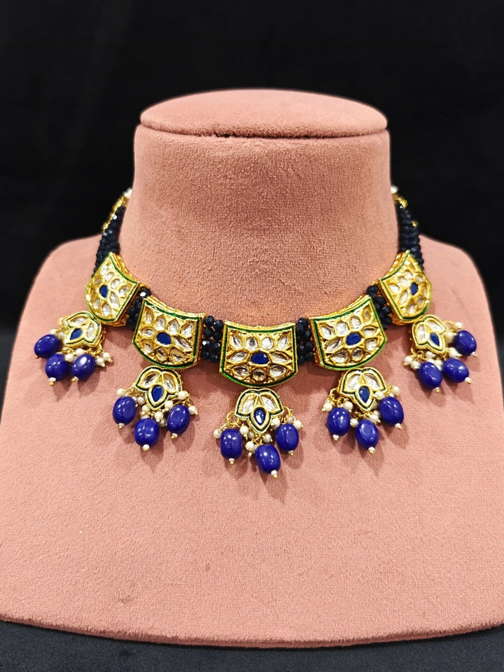 Close-up of an ornate traditional (Gold Polish) Purple Choker jewellery set and earrings with Pearl, Crystal stones, Kundan, Colored Stones and Tumble Beads. Mehendi ceremony look completed with a handcrafted Kundan jewelry set. Wedding celebration look enhanced with a statement Kundan necklace.