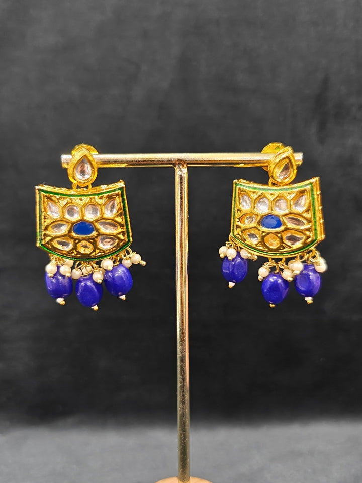 Close-up of an ornate traditional (Gold Polish) Purple Choker jewellery set and earrings with Pearl, Crystal stones, Kundan, Colored Stones and Tumble Beads. Mehendi ceremony look completed with a handcrafted Kundan jewelry set. Wedding celebration look enhanced with a statement Kundan necklace.
