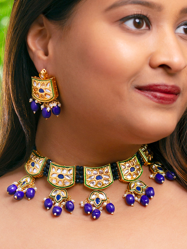 Close-up of a woman wearing an ornate traditional (Gold Polish) Purple Choker jewellery set and earrings with Pearl, Crystal stones, Kundan, Colored Stones and Tumble Beads. Mehendi ceremony look completed with a handcrafted Kundan jewelry set. Wedding celebration look enhanced with a statement Kundan necklace.