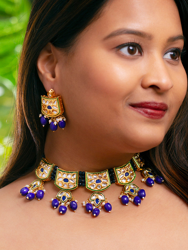 Close-up of a woman wearing an ornate traditional (Gold Polish) Purple Choker jewellery set and earrings with Pearl, Crystal stones, Kundan, Colored Stones and Tumble Beads. Mehendi ceremony look completed with a handcrafted Kundan jewelry set. Wedding celebration look enhanced with a statement Kundan necklace.