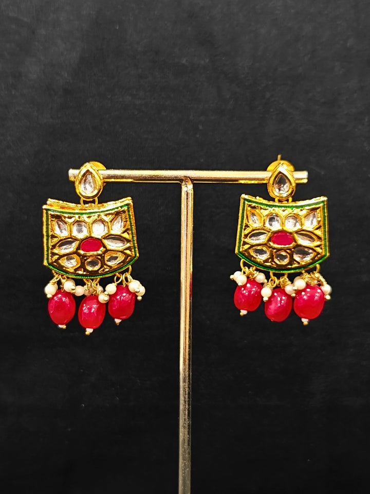 Close-up of an ornate traditional (Gold Polish) Red Choker jewellery set and earrings with Pearl, Crystal stones, Kundan, Colored Stones and Tumble Beads. Mehendi ceremony look completed with a handcrafted Kundan jewelry set. Wedding celebration look enhanced with a statement Kundan necklace.
