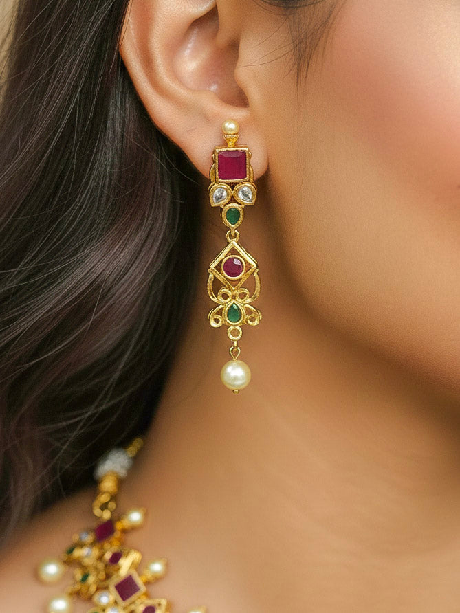 Close-up of a woman wearing an ornate traditional (Gold Polish) Pink jewellery set and earrings with Pearls and Colored Stones. Festive saree styling with a premium artificial Colored Stones necklace. Mehendi ceremony look completed with a handcrafted Colored Stones jewelry set.