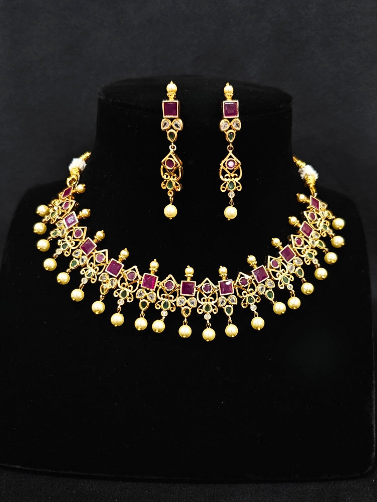 Close-up of an ornate traditional (Gold Polish) Pink jewellery set and earrings with Pearls and Colored Stones. Festive saree styling with a premium artificial Colored Stones necklace. Mehendi ceremony look completed with a handcrafted Colored Stones jewelry set.