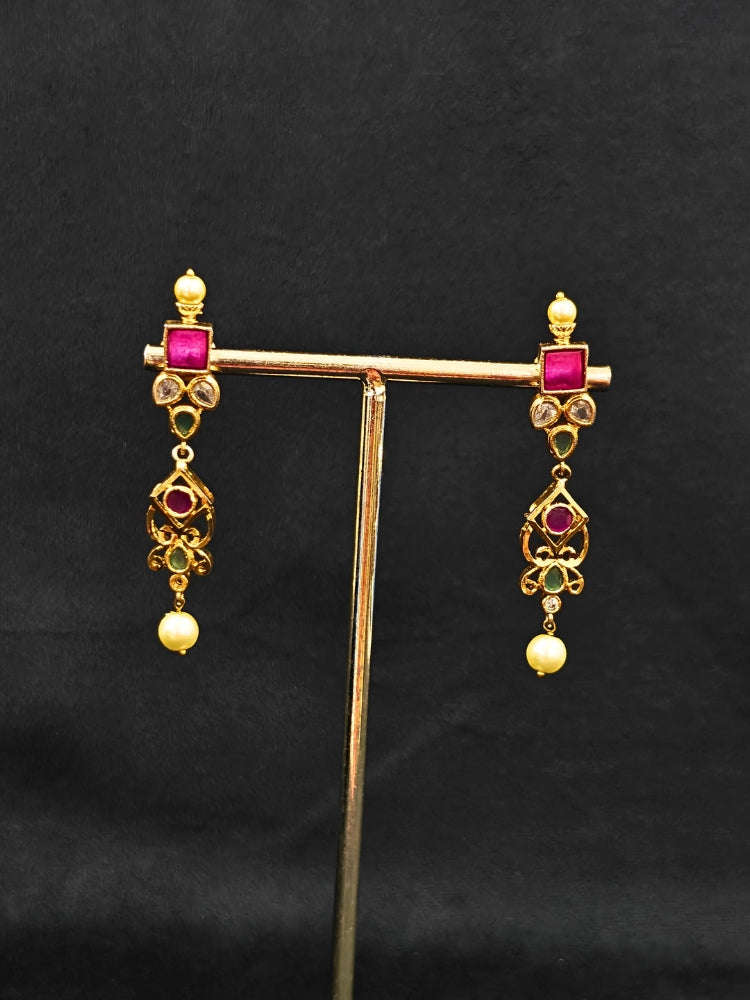 Close-up of an ornate traditional (Gold Polish) Pink jewellery set and earrings with Pearls and Colored Stones. Festive saree styling with a premium artificial Colored Stones necklace. Mehendi ceremony look completed with a handcrafted Colored Stones jewelry set.