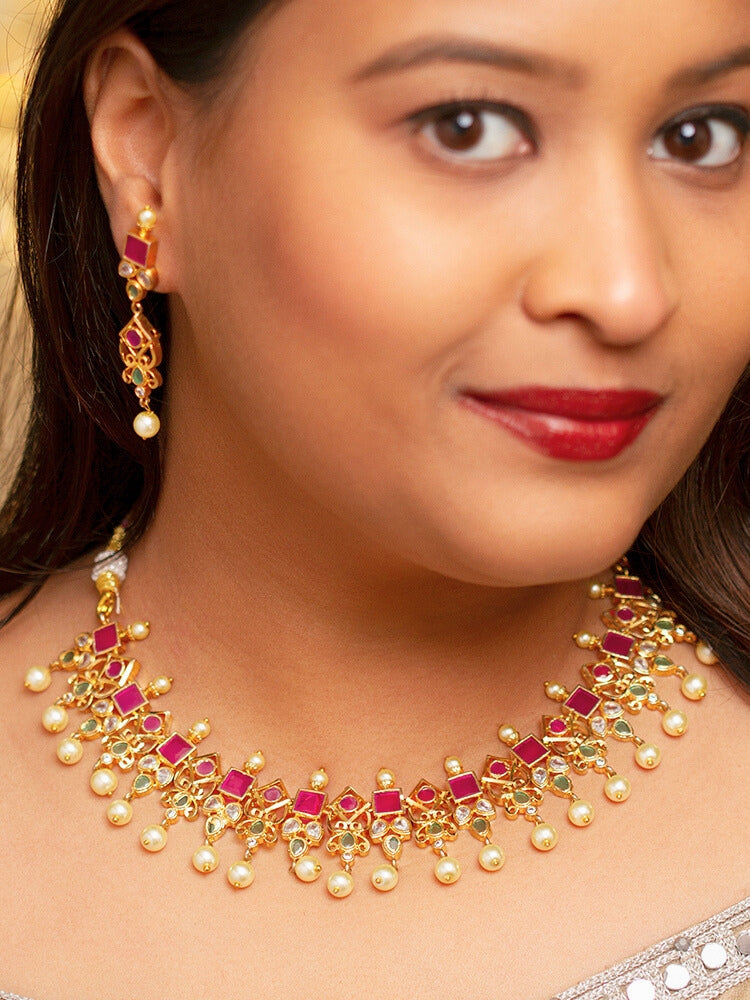 Close-up of a woman wearing an ornate traditional (Gold Polish) Pink jewellery set and earrings with Pearls and Colored Stones. Festive saree styling with a premium artificial Colored Stones necklace. Mehendi ceremony look completed with a handcrafted Colored Stones jewelry set.