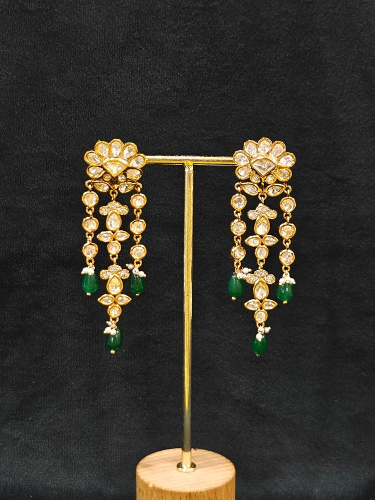 Close-up of an ornate traditional (Gold Polish) Long jewellery set and earrings with Polki, American Diamond Tumble Beads and Pearls. Wedding guest outfit styled with an elegant Polki necklace set. Woman Bridal mehendi outfit paired with a royal Polki artificial jewelry set. wearing trending Polki artificial jewelry for the wedding season in India. 