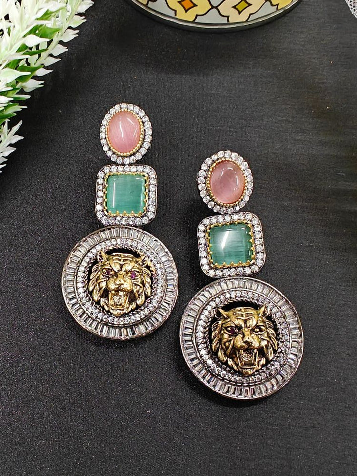 Sabyasachi Inspired Earrings 1: ornate brass earrings with round pink and square green stones, shimmering American Diamonds, and a large circular pendant featuring a detailed roaring tiger head. Sabyasachi Earrings. American Diamond Earrings. Long Earrings. Party Earrings. 