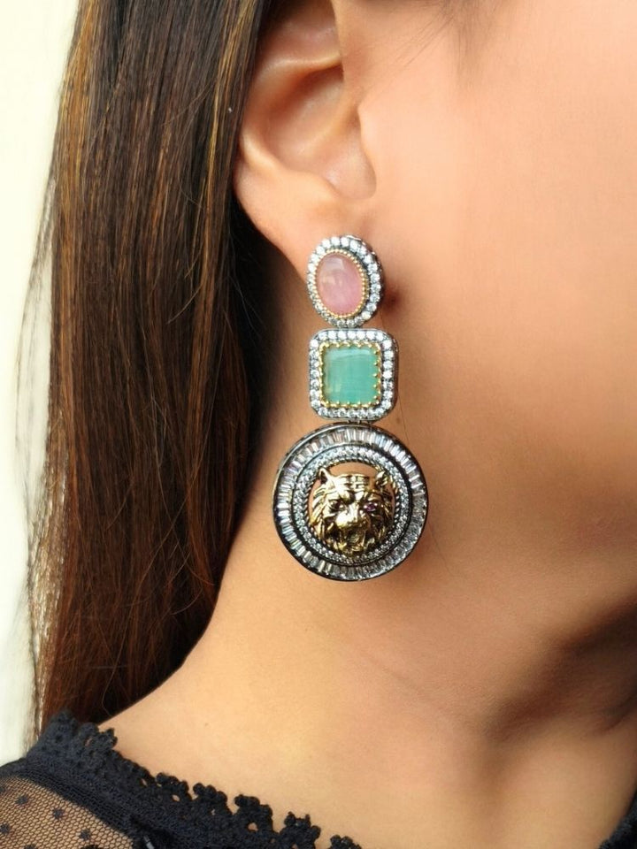 A close-up of a womans ear wearing Sabyasachi Inspired Earrings 1—featuring American Diamonds and a raised gold lion head pendant. She pairs them with straight brown hair and a black lace top, perfect for elevating any cocktail gown. Sabyasachi Earrings. American Diamond Earrings. Long Earrings. Party Earrings. 