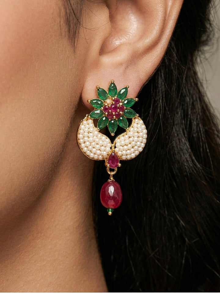 Close-up of a woman wearing an ornate traditional Colored Stones Pendant Set  earrings with Pearl and Colored Stones. Festive celebration look enhanced with traditional Colored Stones jewelry. Close-up of detailed enamel craftsmanship in Colored Stones jewelry.