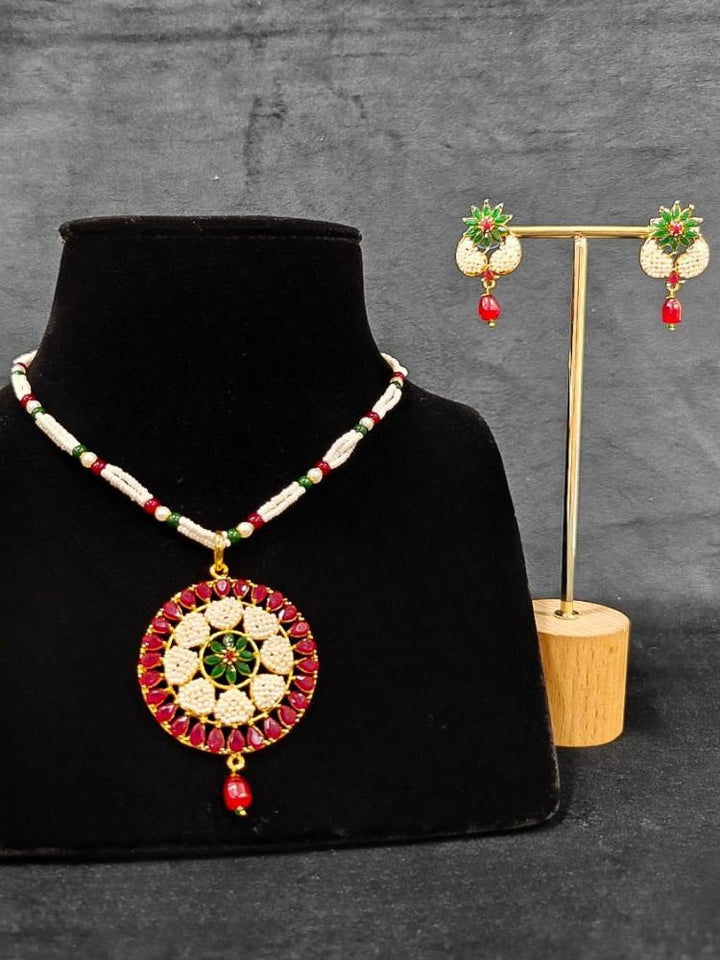 Close-up of an ornate traditional Colored Stones Pendant Set  earrings with Pearl and Colored Stones. Festive celebration look enhanced with traditional Colored Stones jewelry. Close-up of detailed enamel craftsmanship in Colored Stones jewelry.