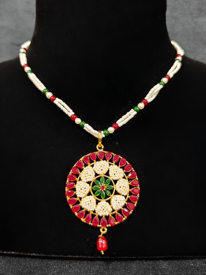 Close-up of an ornate traditional Colored Stones Pendant Set  earrings with Pearl and Colored Stones. Festive celebration look enhanced with traditional Colored Stones jewelry. Close-up of detailed enamel craftsmanship in Colored Stones jewelry.