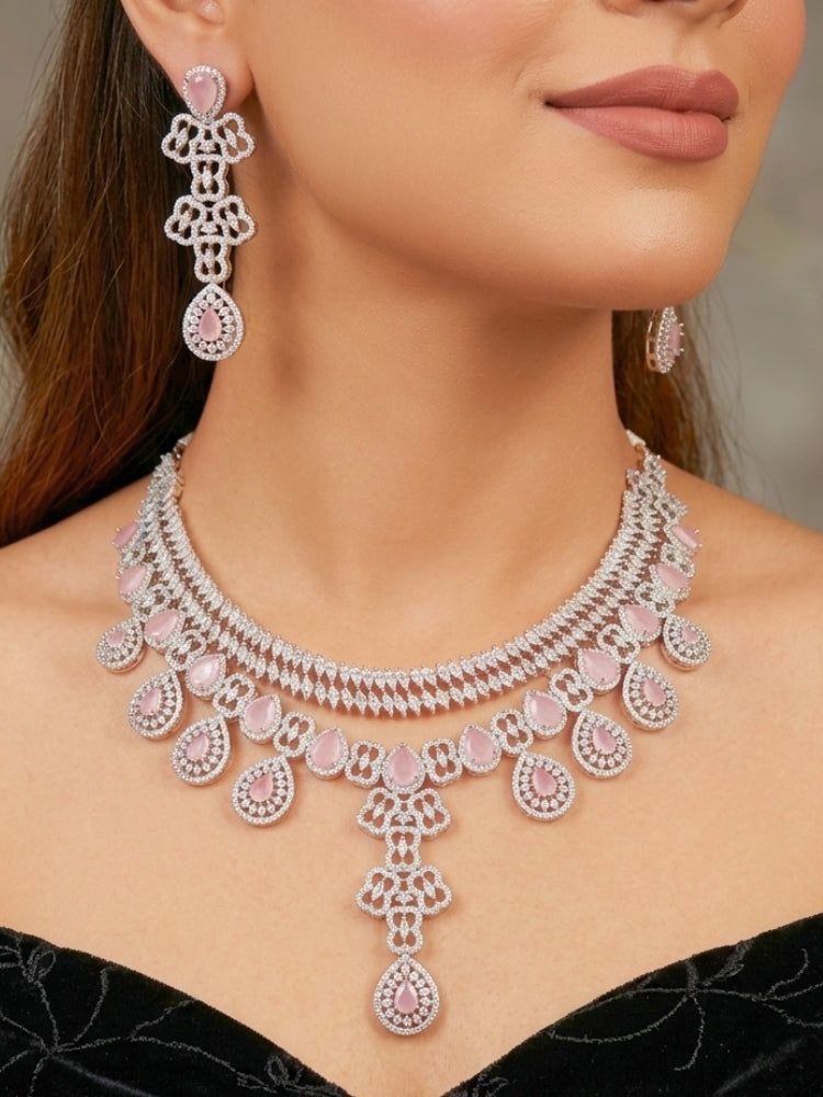 Close-up of a women wearing an ornate Western (Silver Polish) Collar Layered jewellery set and earrings with American Diamond and Mint Pink Colored Stones. Reception-ready look featuring a statement American diamond jewelry set. Elegant wedding jewelry look featuring a premium artificial American diamond necklace.