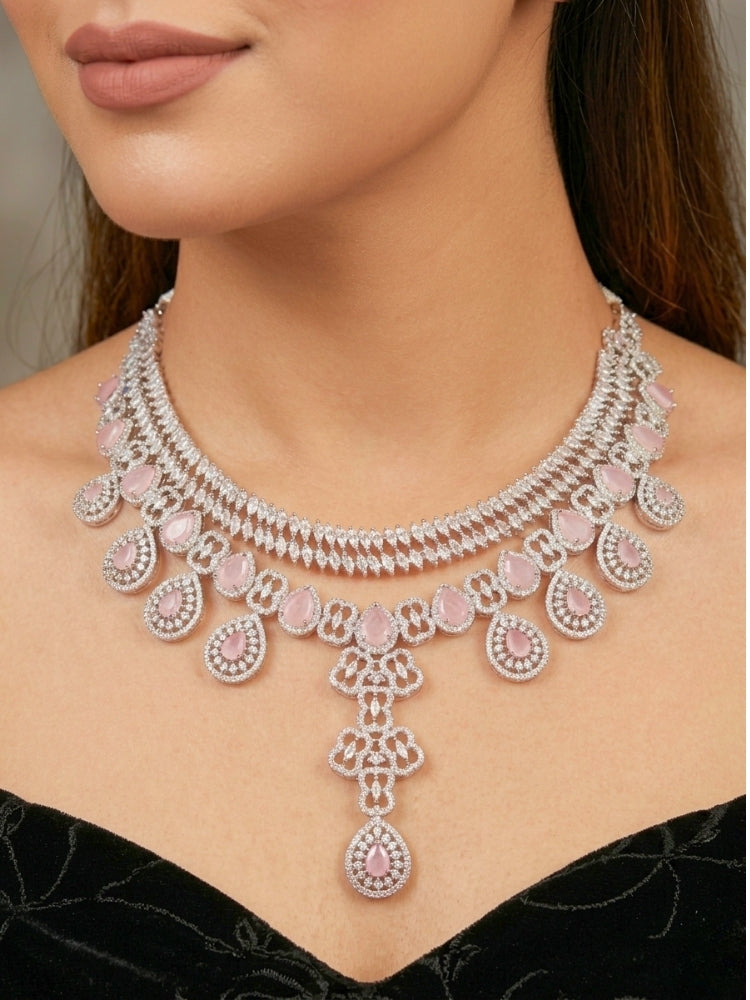 Close-up of a women wearing an ornate Western (Silver Polish) Collar Layered jewellery set and earrings with American Diamond and Mint Pink Colored Stones. Reception-ready look featuring a statement American diamond jewelry set. Elegant wedding jewelry look featuring a premium artificial American diamond necklace.