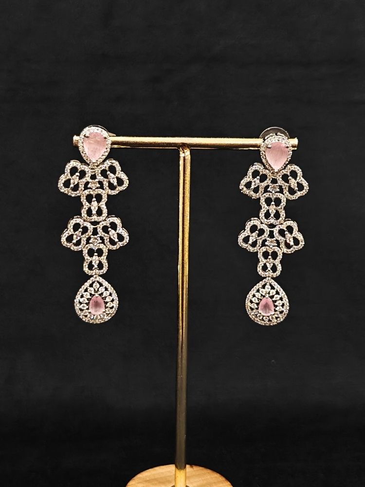 Close-up of an ornate Western (Silver Polish) Collar Layered jewellery set and earrings with American Diamond and Mint Pink Colored Stones. Reception-ready look featuring a statement American diamond jewelry set. Elegant wedding jewelry look featuring a premium artificial American diamond necklace.