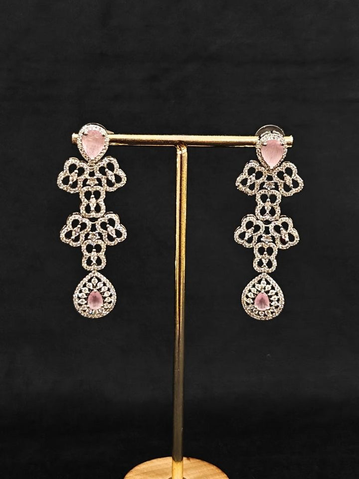 Close-up of an ornate Western (Silver Polish) Collar Layered jewellery set and earrings with American Diamond and Mint Pink Colored Stones. Reception-ready look featuring a statement American diamond jewelry set. Elegant wedding jewelry look featuring a premium artificial American diamond necklace.