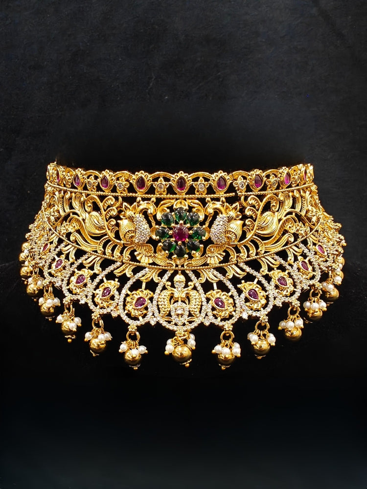 Close-up of an ornate traditional Heritage gold Choker jewellery set and earrings with Pota Stone and American Diamond. Wedding guest look featuring a traditional heritage artificial necklace. Close-up of antique-style detailing in heritage artificial jewelry.
