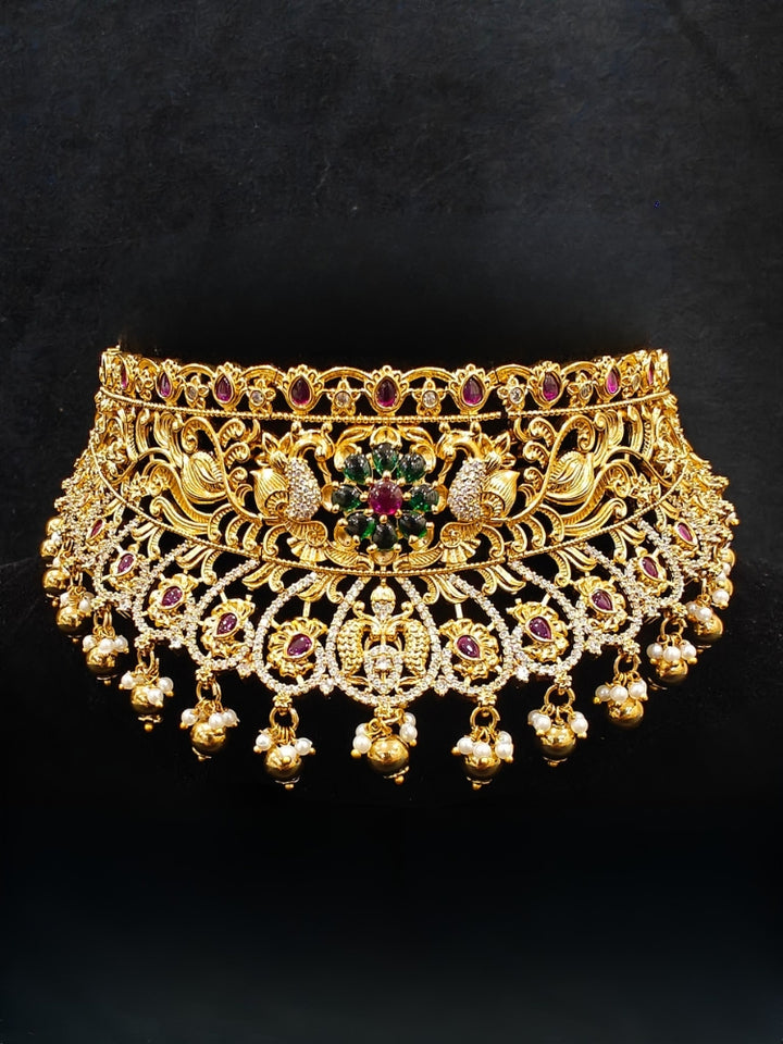 Close-up of an ornate traditional Heritage gold Choker jewellery set and earrings with Pota Stone and American Diamond. Wedding guest look featuring a traditional heritage artificial necklace. Close-up of antique-style detailing in heritage artificial jewelry.