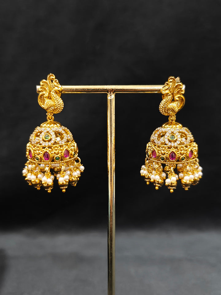 Close-up of an ornate traditional Heritage gold Choker jewellery set and earrings with Pota Stone and American Diamond. Wedding guest look featuring a traditional heritage artificial necklace. Close-up of antique-style detailing in heritage artificial jewelry.