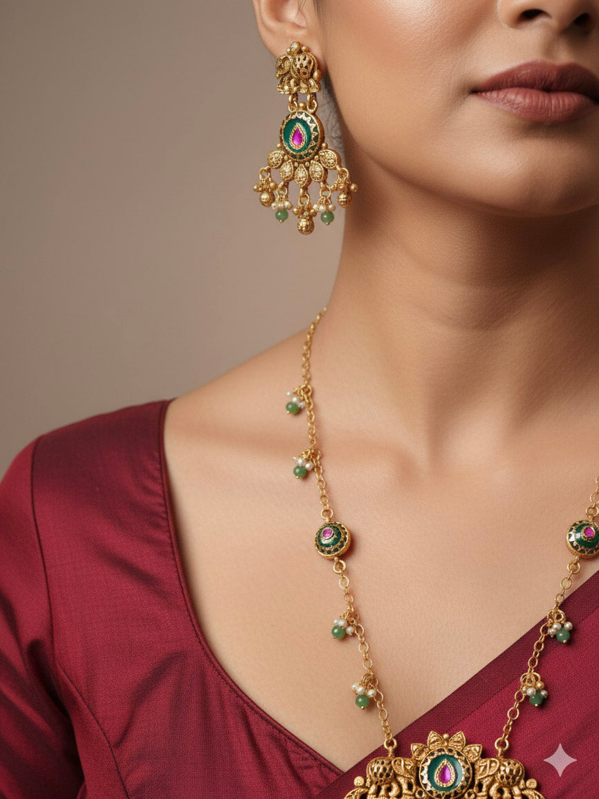 Close-up of a woman wearing an ornate traditional Green Heritage gold jewellery set and earrings with Mint Green Colored Stones, Beads. Festive Diwali outfit styled with a royal heritage necklace. Festive look completed with a luxury Heritage imitation necklace.
