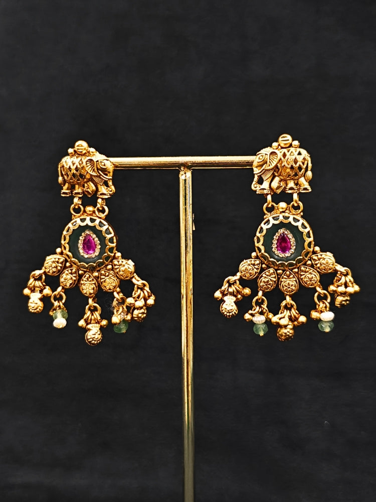 Close-up of an ornate traditional Green Heritage gold jewellery set and earrings with Mint Green Colored Stones, Beads. Festive Diwali outfit styled with a royal heritage necklace. Festive look completed with a luxury Heritage imitation necklace.