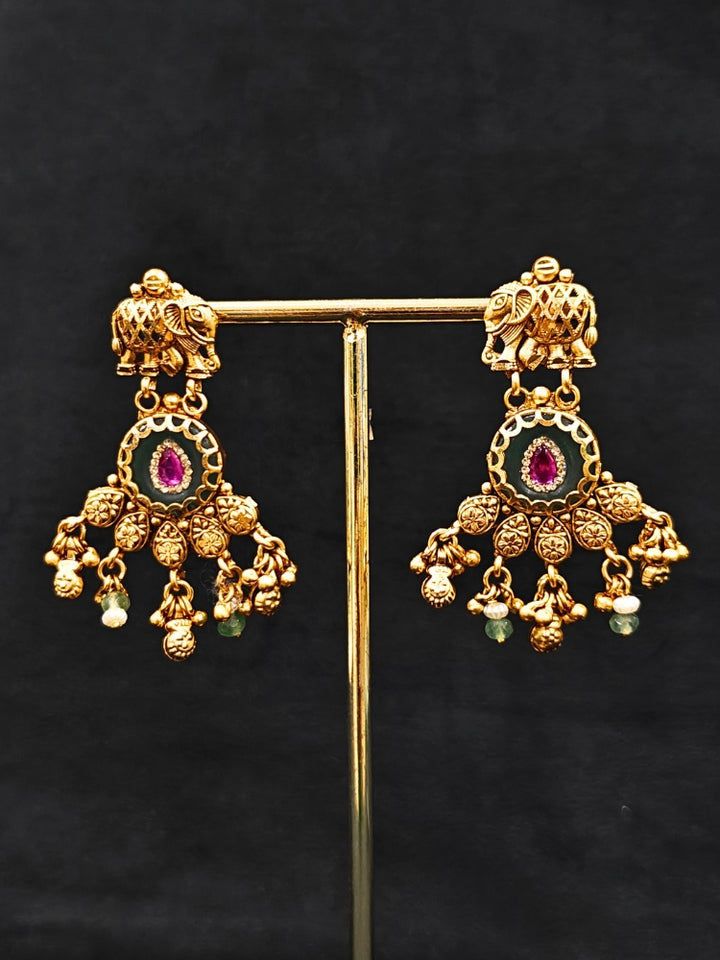 Close-up of an ornate traditional Green Heritage gold jewellery set and earrings with Mint Green Colored Stones, Beads. Festive Diwali outfit styled with a royal heritage necklace. Festive look completed with a luxury Heritage imitation necklace.