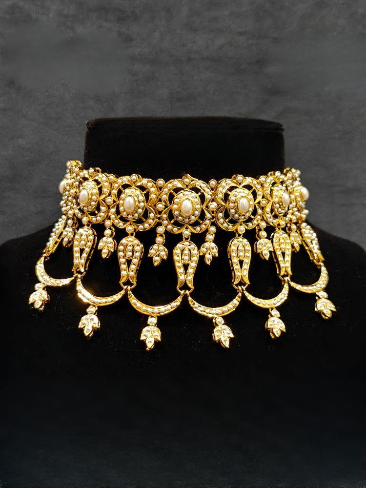 Close-up of an ornate traditional Choker white jadau gold jewellery set and jadau earrings with Pearl. Elegant reception look featuring a luxury Jadau artificial jewelry set. Close-up of high-quality Jadau artificial necklace craftsmanship.