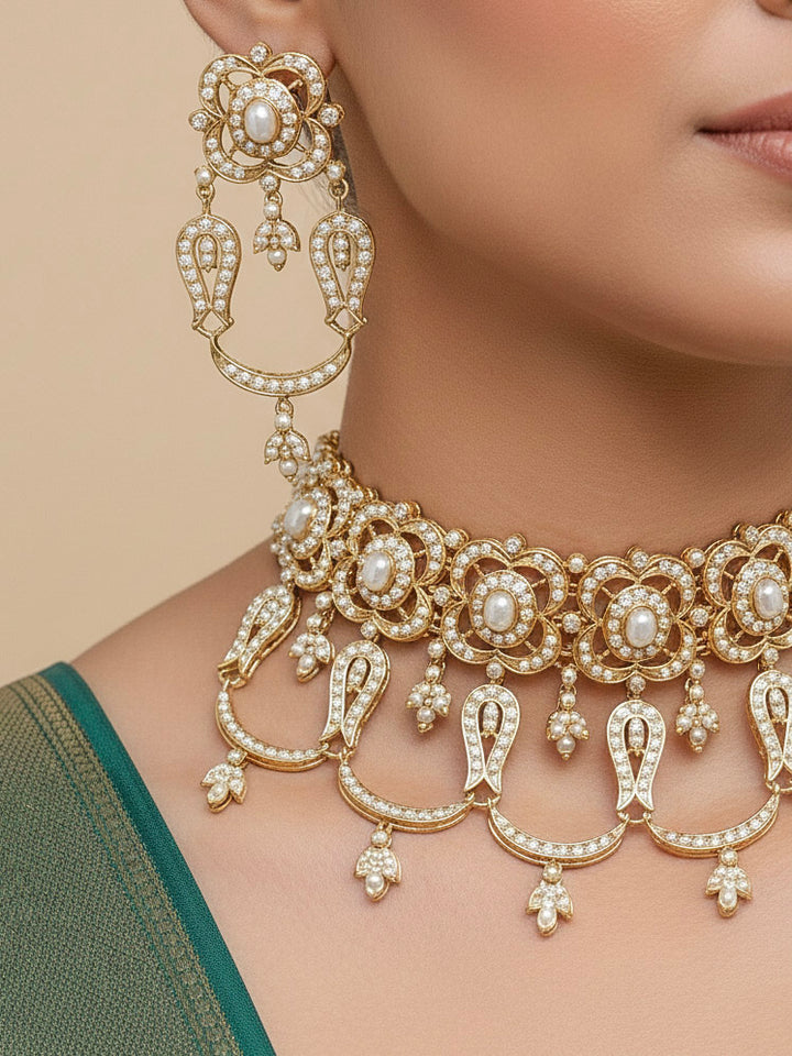 Close-up of a woman wearing an ornate traditional Choker white jadau gold jewellery set and jadau earrings with Pearl. Festive celebration look featuring a Jadau artificial necklace. Woman pairing a traditional Jadau necklace with a silk saree and Lehenga.