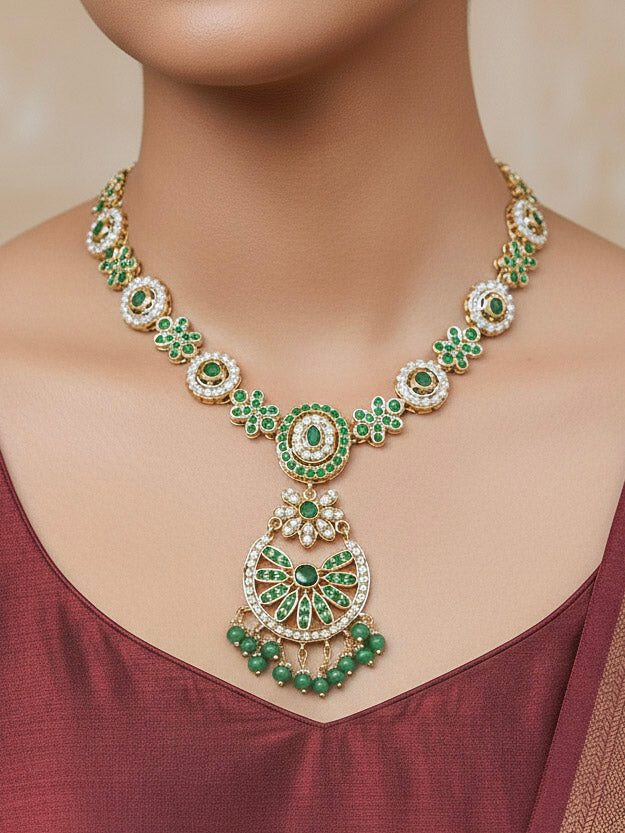 Close-up of a woman wearing an ornate traditional collar Green jadau gold jewellery set and jadau earrings with pearls and Green gemstones. Mehendi function outfit styled with a lightweight Jadau necklace. Bridal styling inspiration with a premium Jadau imitation necklace.