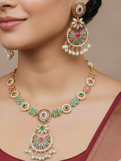 Close-up of a woman wearing an ornate traditional collar Navratan jadau gold jewellery set and jadau earrings with pearls and Navratan gemstones. Elegant  look featuring a luxury Jadau artificial jewelry set. Festive saree look completed with a handcrafted Jadau necklace.