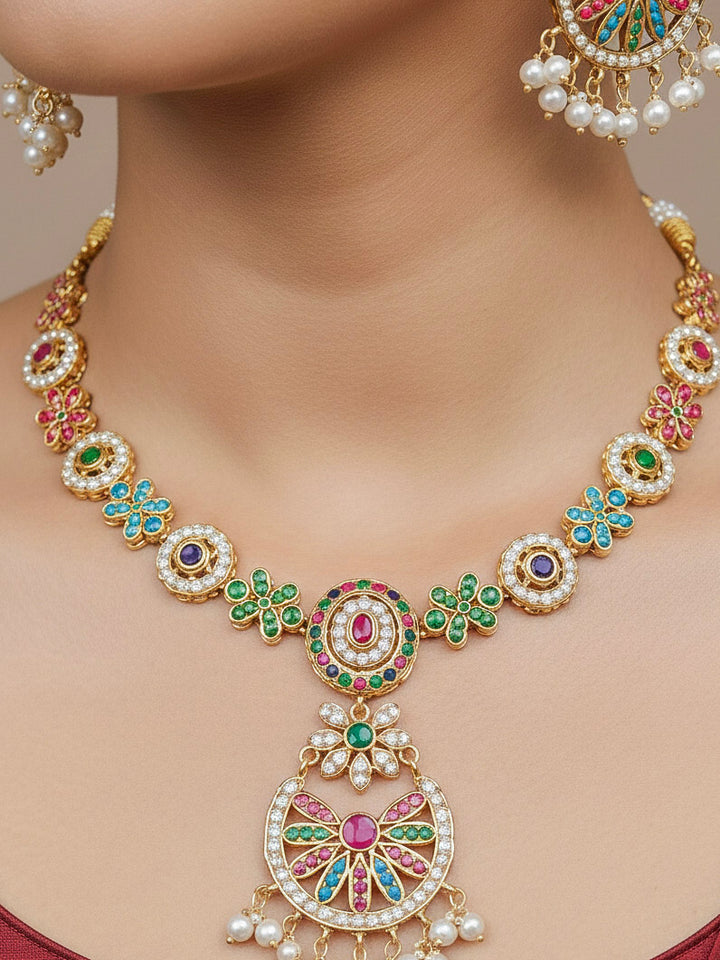 Close-up of a woman wearing an ornate traditional collar Navratan jadau gold jewellery set and jadau earrings with pearls and Navratan gemstones. Elegant  look featuring a luxury Jadau artificial jewelry set. Festive saree look completed with a handcrafted Jadau necklace.