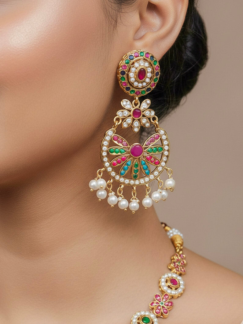 Close-up of a woman wearing an ornate traditional collar Navratan jadau gold jewellery set and jadau earrings with pearls and Navratan gemstones. Elegant  look featuring a luxury Jadau artificial jewelry set. Festive saree look completed with a handcrafted Jadau necklace.