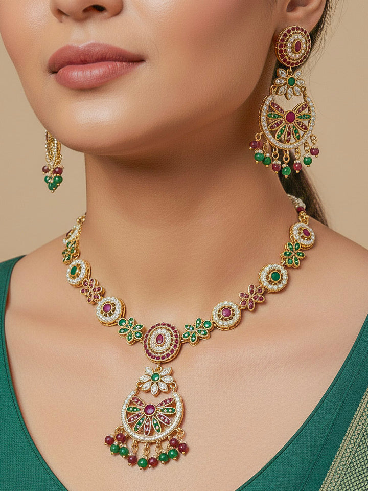 Close-up of a woman wearing an ornate traditional Collar Ruby Pink & Green jadau gold jewellery set and jadau earrings with pearls and Color Stone. Elegant  look featuring a luxury Jadau artificial jewelry set. Close-up of high-quality Jadau artificial necklace craftsmanship.