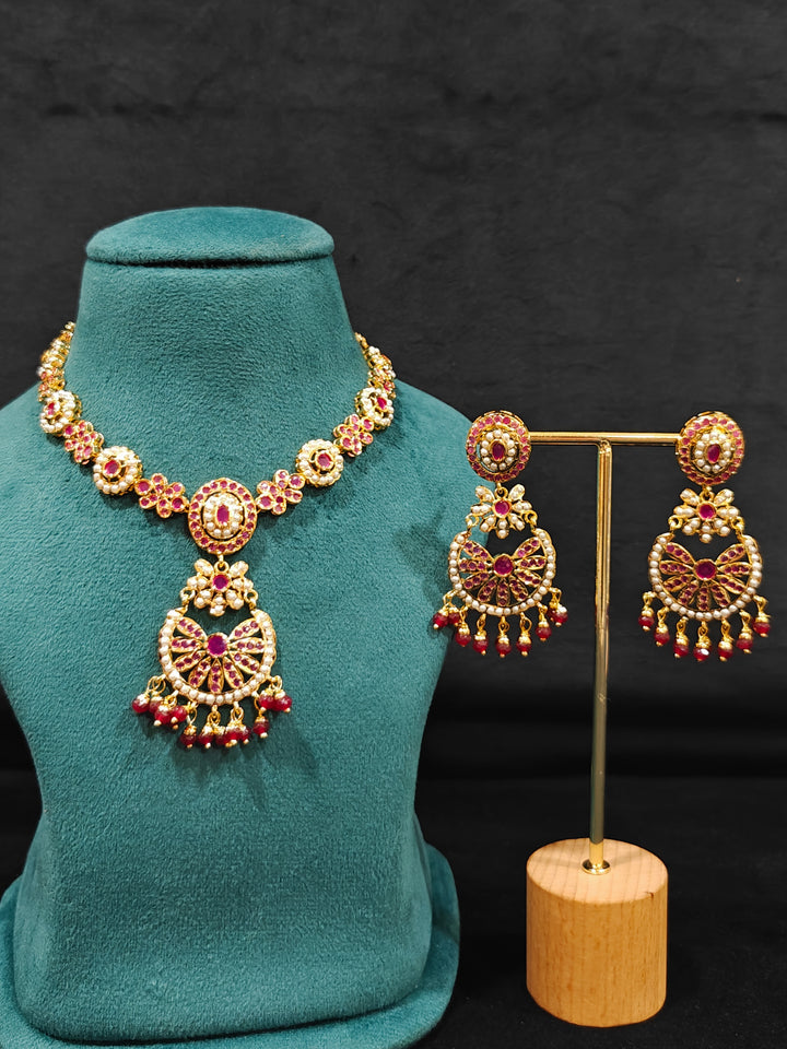 Close-up of an ornate traditional Ruby Pink jadau gold jewellery set and jadau earrings with beads and gemstones. Perfect Jadau necklace set for weddings and festivals. Mehendi function outfit styled with a lightweight Jadau necklace.