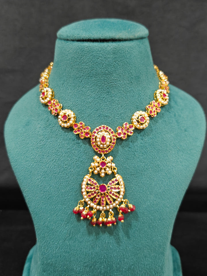 Close-up of an ornate traditional Ruby Pink jadau gold jewellery set and jadau earrings with beads and gemstones. Perfect Jadau necklace set for weddings and festivals. Mehendi function outfit styled with a lightweight Jadau necklace.