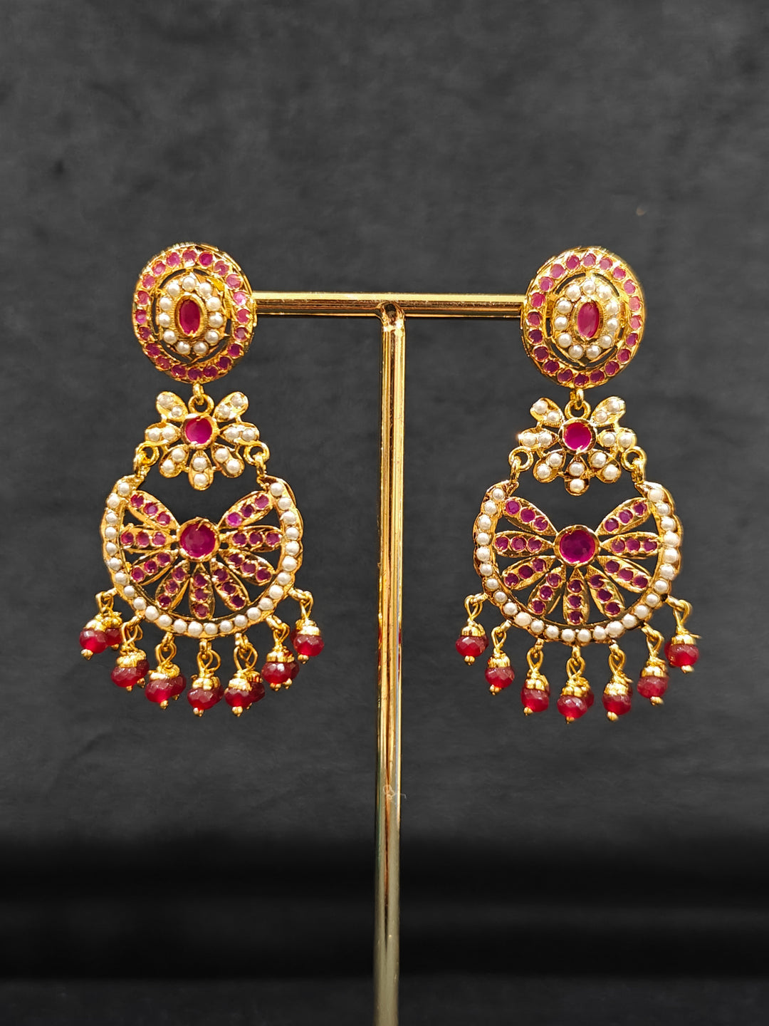 Close-up of an ornate traditional Ruby Pink jadau gold jewellery set and jadau earrings with beads and gemstones. Perfect Jadau necklace set for weddings and festivals. Mehendi function outfit styled with a lightweight Jadau necklace.