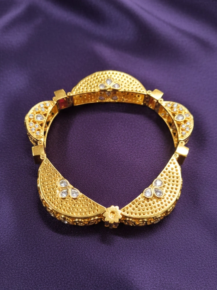 Close-up of an ornate Traditional American Diamond Bracelet with Gold Polish, American Diamond, Colored Stones, Pearls and Filigree Work. Festive outfit paired with a premium imitation American Diamond bracelet in India. Close-up of a high-quality imitation bracelet for festive wear.