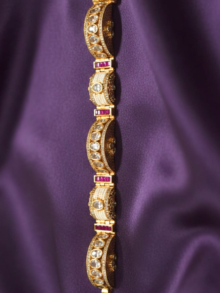 Close-up of an ornate Traditional American Diamond Bracelet with Gold Polish, American Diamond, Colored Stones, Pearls and Filigree Work. Festive outfit paired with a premium imitation American Diamond bracelet in India. Close-up of a high-quality imitation bracelet for festive wear.