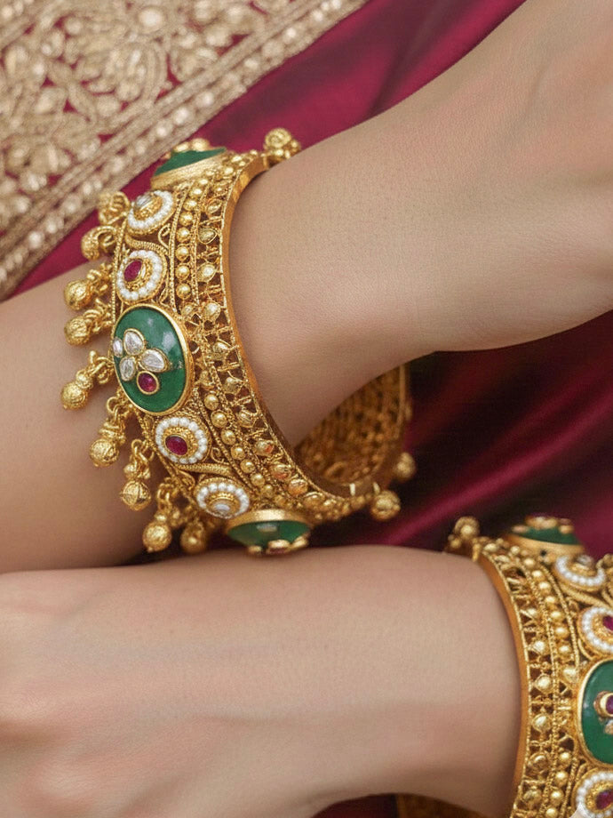 Close-up of a woman wearing an ornate traditional Mint Green Heritage gold Bangle with Colored Stones , Pearls and Kundan. Woman wearing a heritage-inspired artificial Bangles for wedding festivities. Luxury artificial Heritage bangles styled for a wedding function.