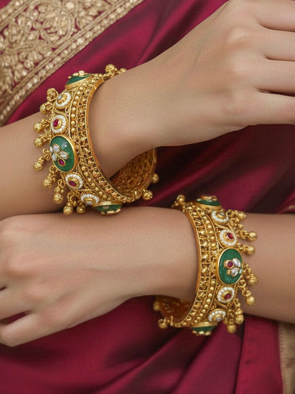 Close-up of a woman wearing an ornate traditional Mint Green Heritage gold Bangle with Colored Stones , Pearls and Kundan. Woman wearing a heritage-inspired artificial Bangles for wedding festivities. Luxury artificial Heritage bangles styled for a wedding function.