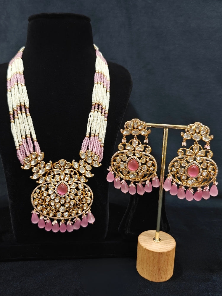Close-up of an ornate traditional (Gold Polish) Mint Pink Long jewellery set and earrings with Polki, American Diamond, Pearls, Crystal Beads and Tumble Beads. Wedding guest wearing a statement Polki artificial necklace for a reception party. Festive celebration look completed with premium imitation Polki jewelry.