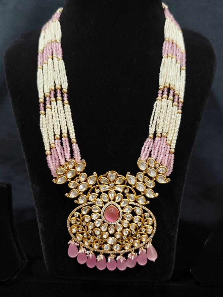 Close-up of an ornate traditional (Gold Polish) Mint Pink Long jewellery set and earrings with Polki, American Diamond, Pearls, Crystal Beads and Tumble Beads. Wedding guest wearing a statement Polki artificial necklace for a reception party. Festive celebration look completed with premium imitation Polki jewelry.