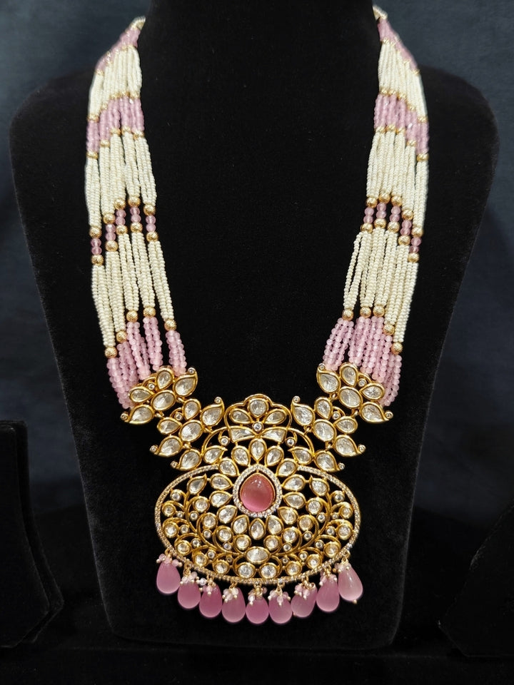 Close-up of an ornate traditional (Gold Polish) Mint Pink Long jewellery set and earrings with Polki, American Diamond, Pearls, Crystal Beads and Tumble Beads. Wedding guest wearing a statement Polki artificial necklace for a reception party. Festive celebration look completed with premium imitation Polki jewelry.