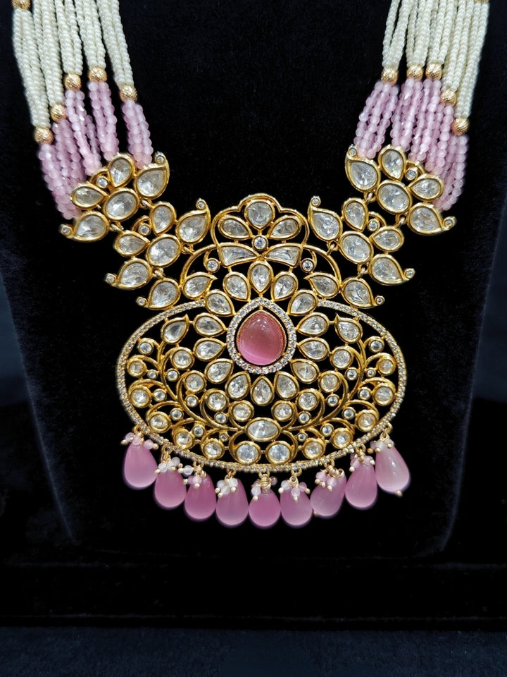 Close-up of an ornate traditional (Gold Polish) Mint Pink Long jewellery set and earrings with Polki, American Diamond, Pearls, Crystal Beads and Tumble Beads. Wedding guest wearing a statement Polki artificial necklace for a reception party. Festive celebration look completed with premium imitation Polki jewelry.
