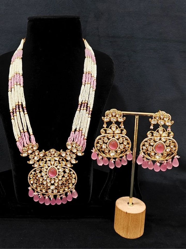 Close-up of an ornate traditional (Gold Polish) Mint Pink Long jewellery set and earrings with Polki, American Diamond, Pearls, Crystal Beads and Tumble Beads. Wedding guest wearing a statement Polki artificial necklace for a reception party. Festive celebration look completed with premium imitation Polki jewelry.